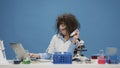 Funny insane female scientist looking at test tubes on desk