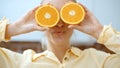 Young woman holding orange slices near her eyes and smiling. Royalty Free Stock Photo