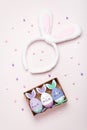 Funny kawaii bunny eggs and bunny rabbit ears for kids on pastel pink table top, Easter holiday concept. Easter decoration and set