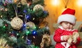 Funny kid baby with Christmas gift. Christmas kids. Cute little baby is decorating the Christmas tree indoors. Happy