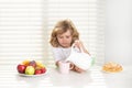 Funny kid boy having breakfast. Cute child pouring whole cows milk. Milk, vegetables and fruits healthy food nutrition Royalty Free Stock Photo