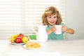 Funny kid boy having breakfast. Milk, vegetables and fruits healthy food nutrition for children. Milk for children