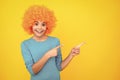 Funny kid with curly hair wig. Cute little girl with fancy hair. Child wearing bright redhead clown hair wig. Happy Royalty Free Stock Photo