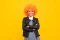 Funny kid in curly redhead wig. Time to have fun. Teen girl with orange hair, being a clown. Happy girl face, positive Royalty Free Stock Photo