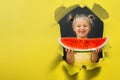Funny kid eating watermelon outdoors on the gray backgrounds