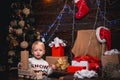 Funny kid holding Christmas gift. Christmas kids. Cute little child is decorating the Christmas tree indoors. Kids
