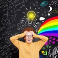 Funny kid. How do I choose the right career path? Child student boy with science and art pattern on blackboard background Royalty Free Stock Photo