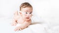 Funny kid lies on the white bed with glasses and reads a book. Prodigy. smart kid. Childish sadness. crying baby