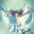 Funny kid making snow angel. Child girl playing and making a snow angel in the snow. Top view. Royalty Free Stock Photo