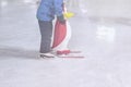 Funny kid outdoors in the park on skating rink in winter park