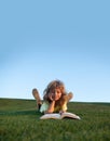 Funny kid reading the book in spring park. Child boy with a book in the garden. Kid is readding a book playing outdoors