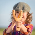 Funny kid shooting wooden slingshot Royalty Free Stock Photo