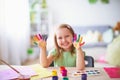 Funny kid show their palms the painted paint. creative classes fine arts. child girl laugh. happy kid in drawing school Royalty Free Stock Photo