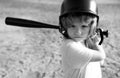 Funny kid up to bat at a baseball game. Close up child portrait.