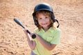 Funny kid up to bat at a baseball game. Close up child portrait.