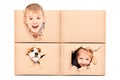 Funny kids and dog looks out of a torn hole in a box Royalty Free Stock Photo