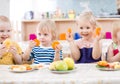 Funny kids eating fruits in kindergarten dinning room Royalty Free Stock Photo