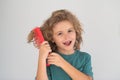 Funny kids hairstyle. Cute child with comb. Blonde kid combs unruly hair. Kid boy with tangled long hair.