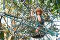 Funny kids, healthy teenager school boy enjoying activity in a climbing adventure park on a summer day. Boy climbing Royalty Free Stock Photo