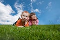 Funny kids lying on grass with blue sky Royalty Free Stock Photo