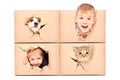 Funny kids and pets looking out of a torn hole in a box Royalty Free Stock Photo