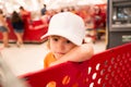 Funny kids shopping. Joyful beautiful child boy in supermarket buys vegetables. Healthy food for children. Royalty Free Stock Photo