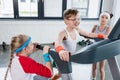 Funny kids in sportswear training on treadmill at gym together