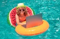 Funny kids summer face. Kid boy relaxing in the pool, using laptop computer in summer water. Child online study or Royalty Free Stock Photo