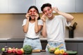 Funny Korean Couple Cooking Having Fun With Vegetables In Kitchen Royalty Free Stock Photo