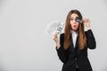 Funny lady grimacing and holding cash and credit card in hands Royalty Free Stock Photo