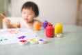 Funny laughing asian baby girl drawing with colorful pencils at Royalty Free Stock Photo