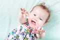 Funny laughing baby girl playing on a green blanket Royalty Free Stock Photo