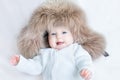 Funny laughing baby girl wearing huge winter hat Royalty Free Stock Photo