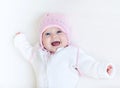 Funny laughing baby girl in white knitted sweater