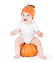 Funny laughing little baby on huge pumpkin