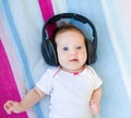 Funny laughing newborn baby listening ear phones Royalty Free Stock Photo