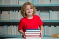 Funny laughing pupil. Child at school. Schoolboy reading book in library. School boy, little student laughing on school Royalty Free Stock Photo