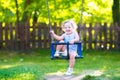 Funny laughing toddler girl swinging ride on playground Royalty Free Stock Photo