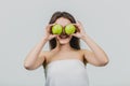 Funny laughing woman holding two green apples in her eyes. White background of a healthy eating concept. Diet Royalty Free Stock Photo