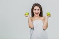 Funny laughing woman holding two green apples in her eyes. White background of a healthy eating concept. Diet Royalty Free Stock Photo
