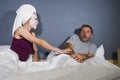Funny lifestyle portrait of man and woman featuring weird married couple with wife in head towel and makeup face mask demanding se