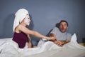 Funny lifestyle portrait of man and woman featuring weird married couple with wife in head towel and makeup face mask demanding se Royalty Free Stock Photo