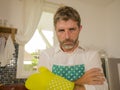 Funny lifestyle portrait of mid adult unhappy and stressed man in kitchen apron feeling frustrated and upset overwhelmed by Royalty Free Stock Photo