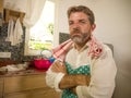 Funny lifestyle portrait of mid adult unhappy and stressed man in kitchen apron feeling frustrated and upset overwhelmed by Royalty Free Stock Photo