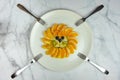 funny lion face composition with fruits like orange blueberry on marble table with forks