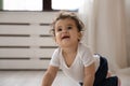 Funny little african american baby creeping on wooden warm floor. Royalty Free Stock Photo