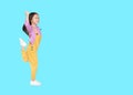 Funny little Asian child girl in pink-yellow dungarees jumping or running over cyan background with copy space. Freedom kid