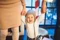 Funny little baby boy 1 year old learning walk home in winter in a decorated New Year house. Young family dad and mom Royalty Free Stock Photo