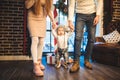 Funny little baby boy 1 year old learning walk home in winter in a decorated New Year house. Young family dad and mom Royalty Free Stock Photo