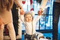 Funny little baby boy 1 year old learning walk home in winter in a decorated New Year house. Young family dad and mom hold by the Royalty Free Stock Photo